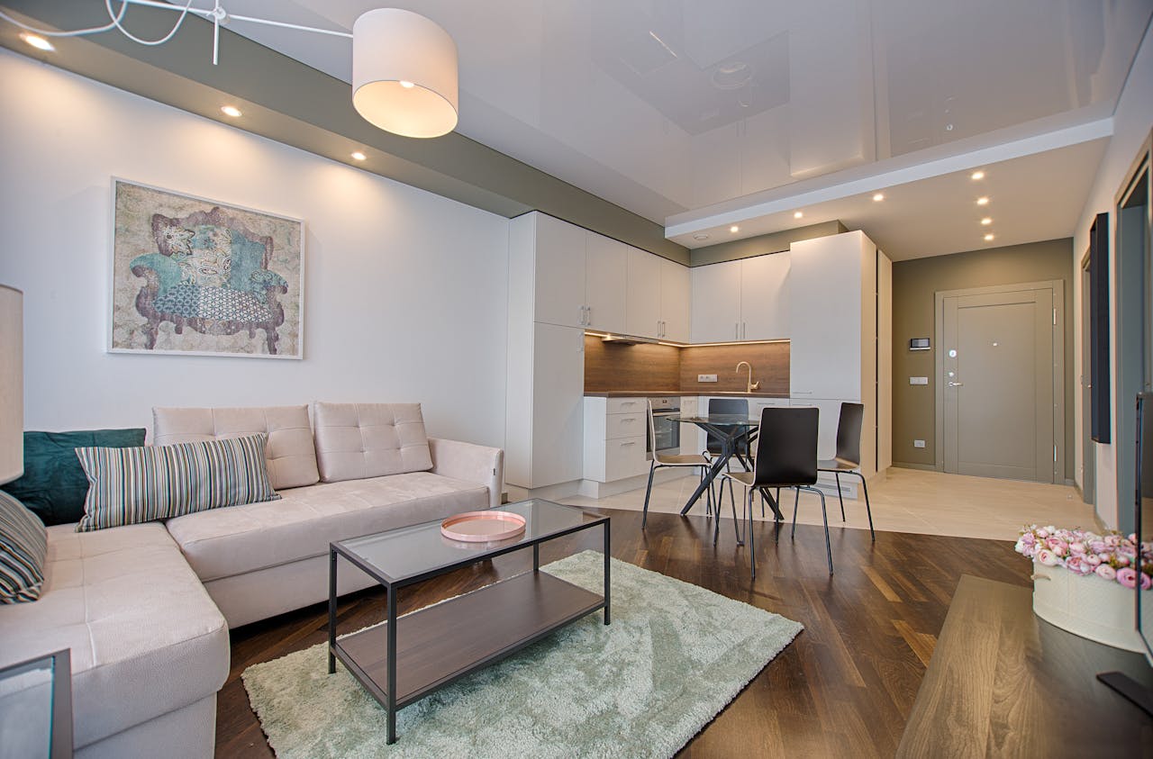 services-04 Spacious modern living room featuring chic furniture, stylish decor, and a minimalist kitchen.