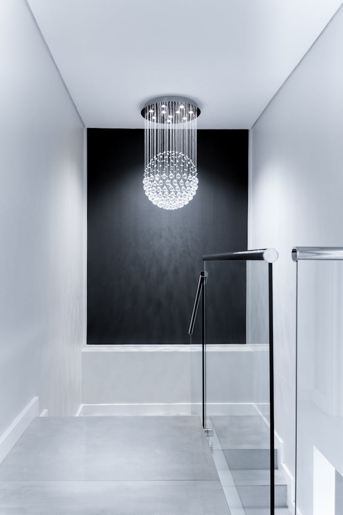 heros-img Sleek contemporary hallway featuring a stunning glass chandelier and minimalist design.